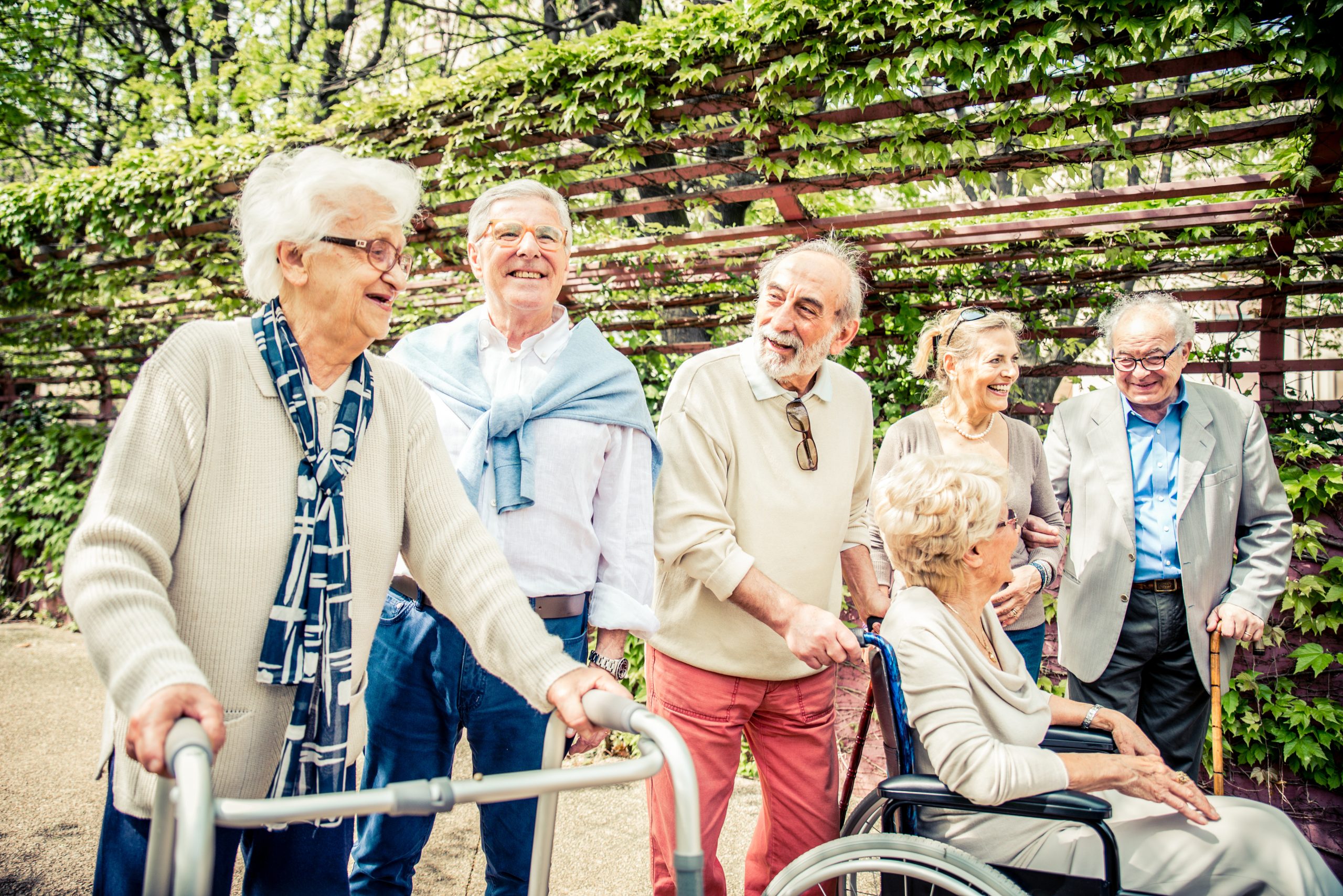 Group of senior people with some diseases walking outdoors - Mature group of friends spending time together